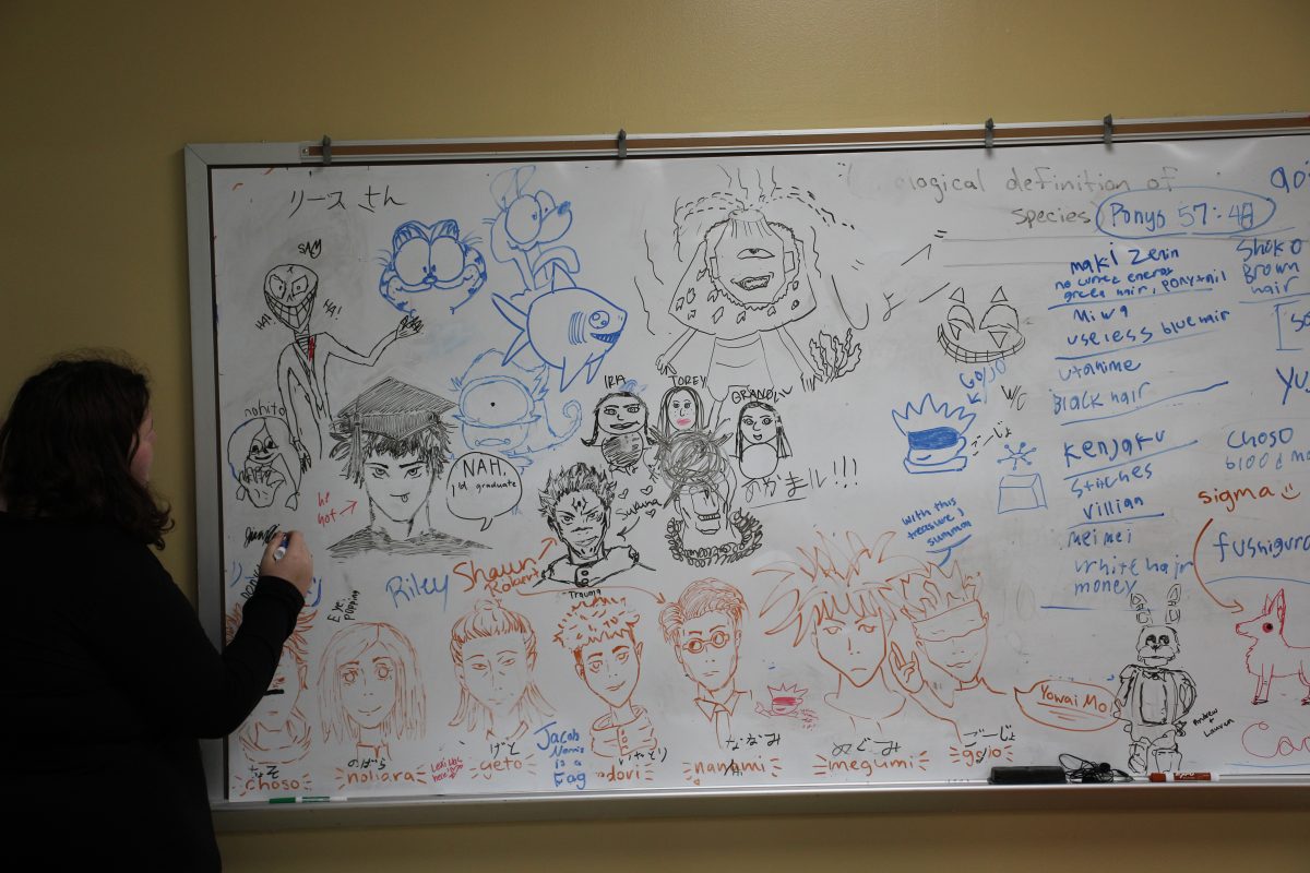 Senior Ariel Harman draws on the Anime Club doodle board.