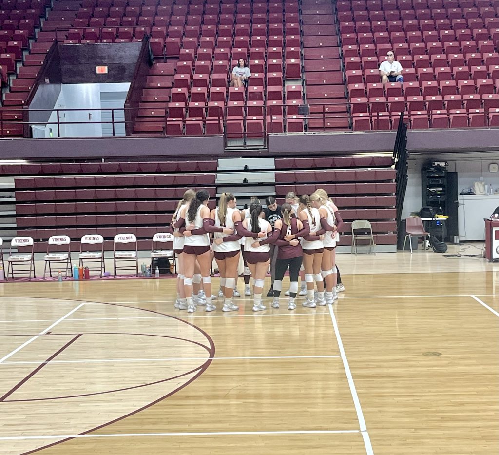 Lady Viking Volleyball team huddles together during time-out.