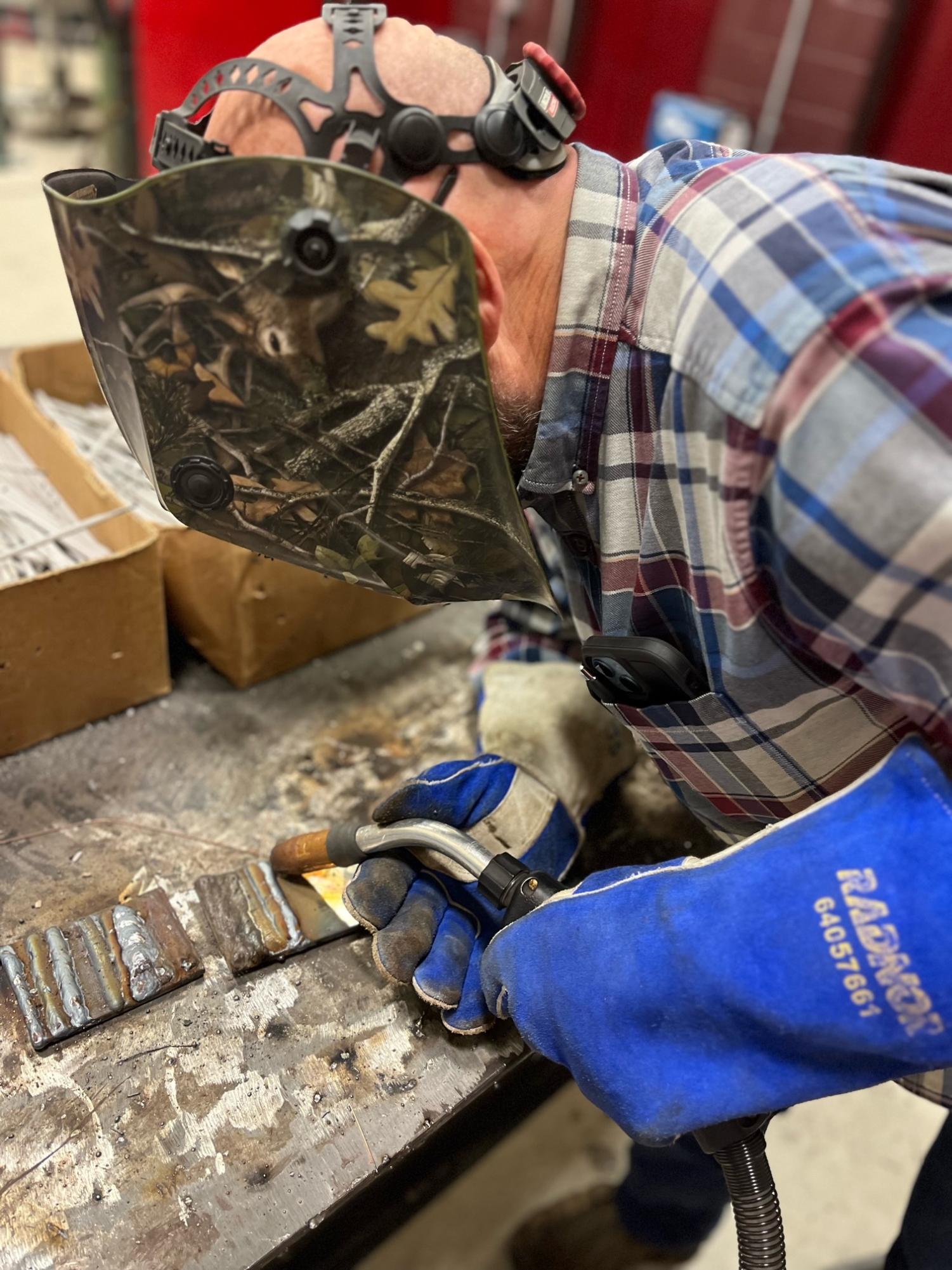 CTE welding instructor Jeff Simcox welds an example for class.  Simcox also recently published a book of historical fiction titled My Father's Place inspired by his experiences hiking through the Blue Ridge Mountains.