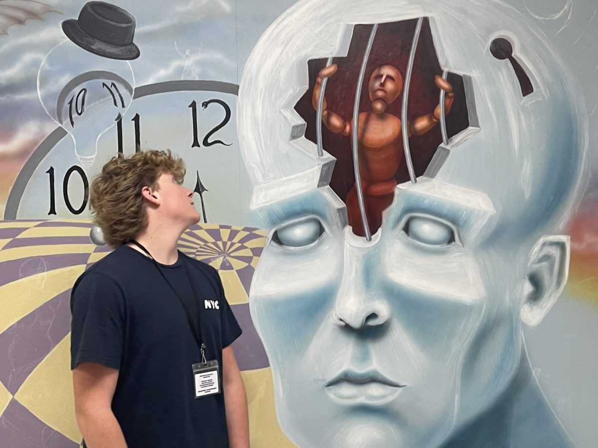 Bryant Rife observing the mural located in the Art hallway.