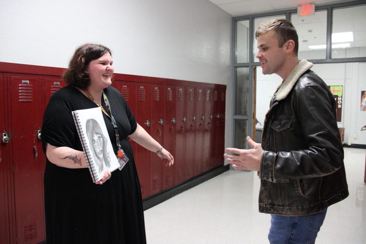 Student Council member Ariel Harman shows Advisor Lucas Gentry her art