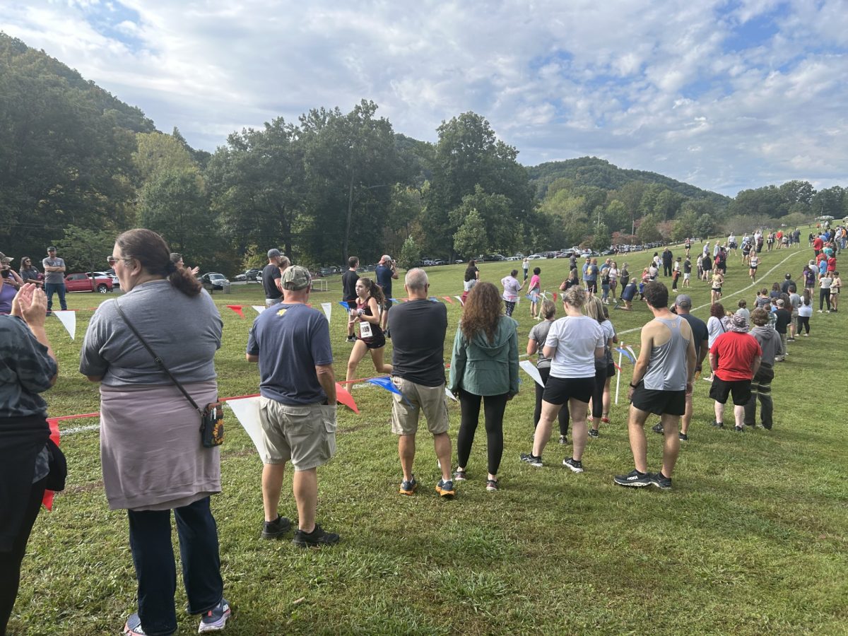 Cross country fans watch as senior Jenna Reecher runs the home stretch of her 5K in Bristol Cross, held Sept. 27th at Steele Creek Park in Bristol, TN.