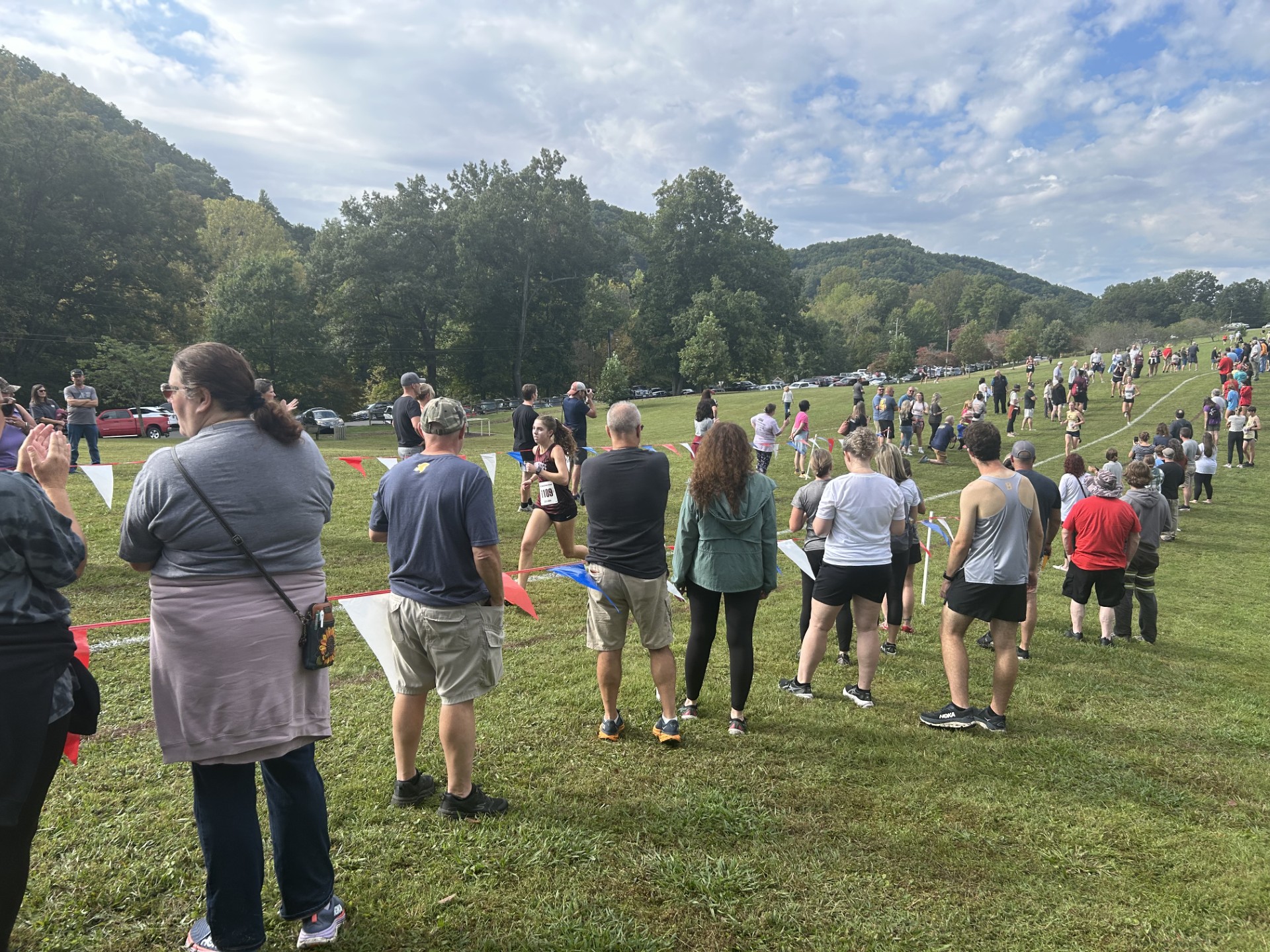 Cross country fans watch as senior Jenna Reecher runs the home stretch of her 5K in Bristol Cross, held Sept. 27th at Steele Creek Park in Bristol, TN.