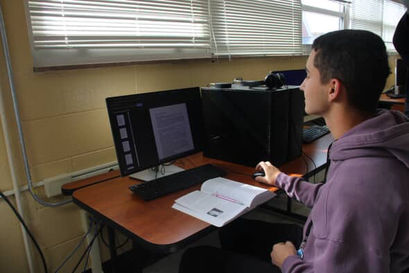 Junior and dual-enrollment student Evan Clarke works on his online college assignment.