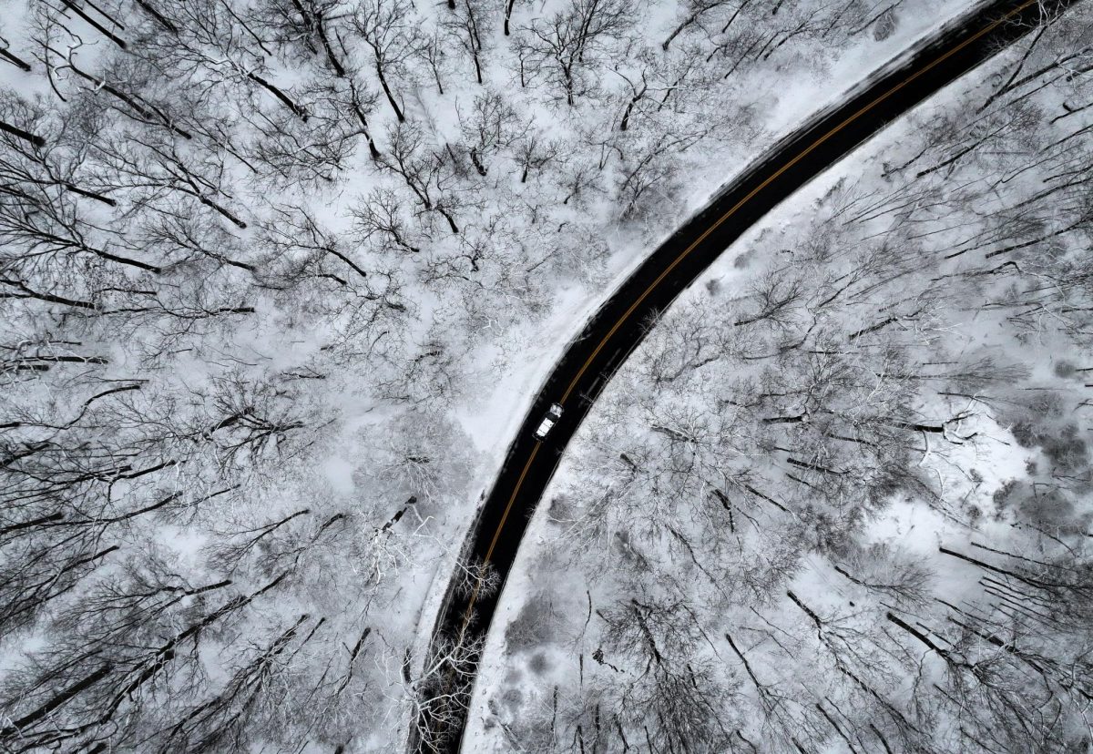 A drone view of a car driving through the snow covered woods of Blauvelt State Park in Orangetown, New York, U.S., December 27, 2025. REUTERS/Mike Segar